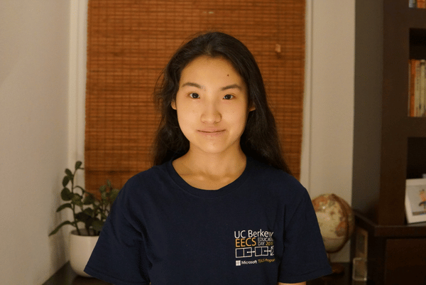Photograph of Carmen He in front of a bookshelf.